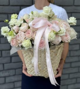 Bouquet of peonies with eustoma and roses in a basket