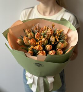 Bouquet of twenty-five orange tulips with ilex